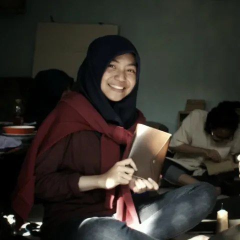 Peserta tersenyum memegang jurnal rancangannya sendiri