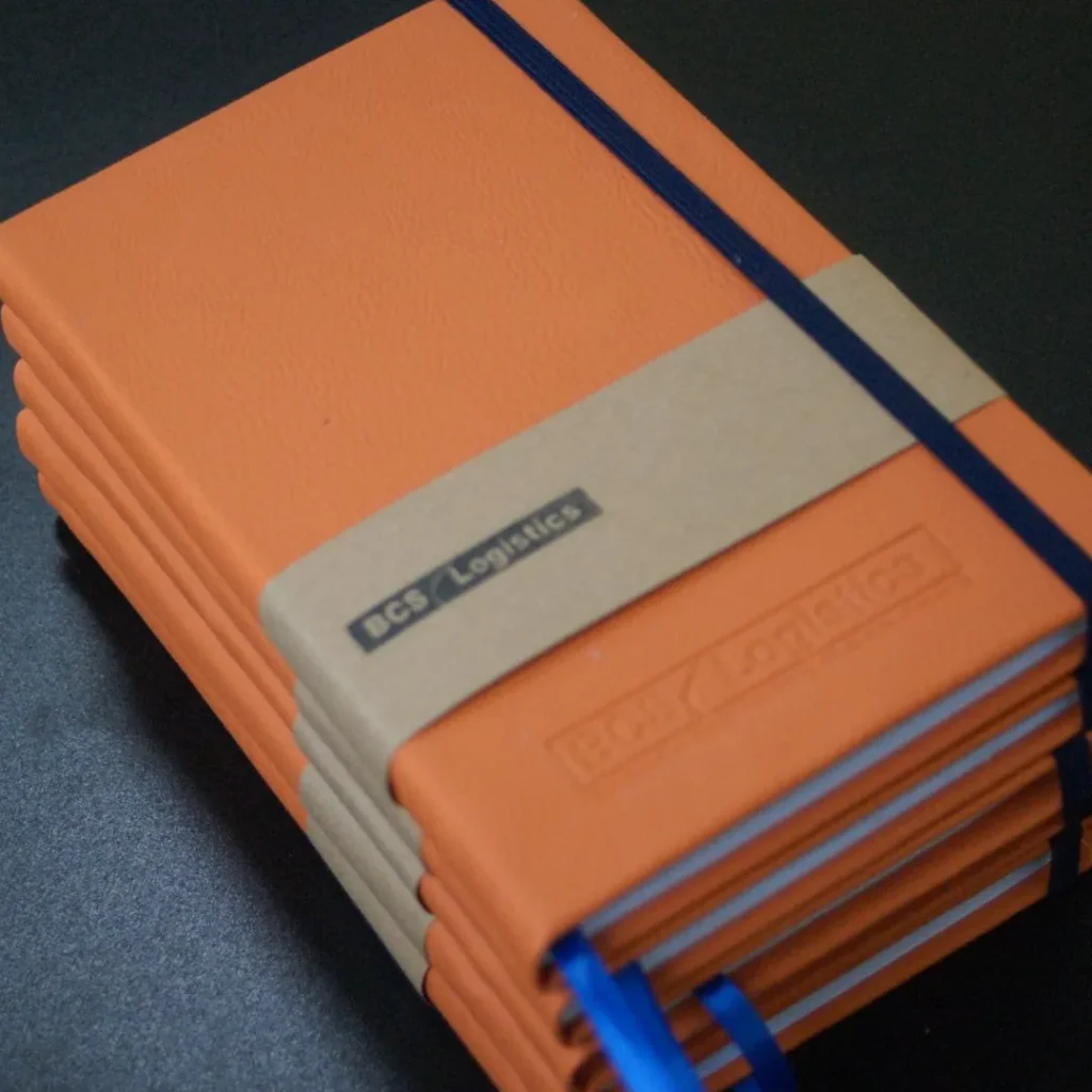 Tumpukan notebook oranye untuk BCS Logistics