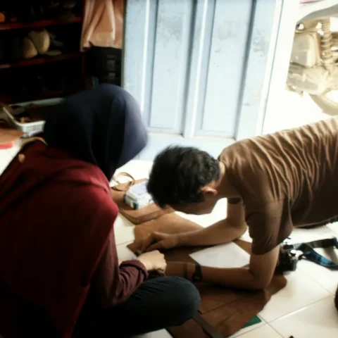 Sepasang peserta mengerjakan jurnal berdua di dekat jendela