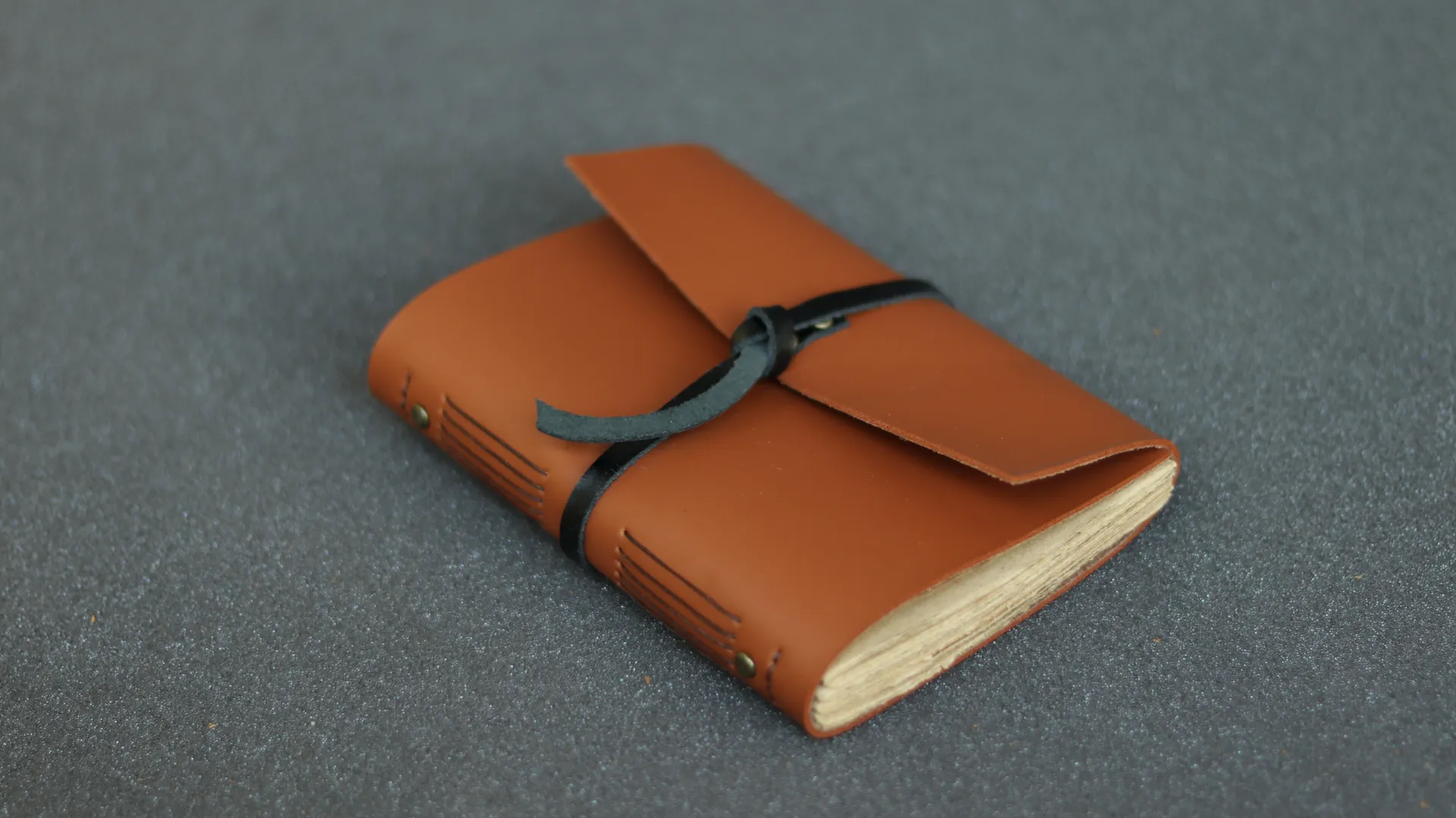 Agenda kulit custom warna cognac dengan tali pengikat dan jahitan longstitch di punggung