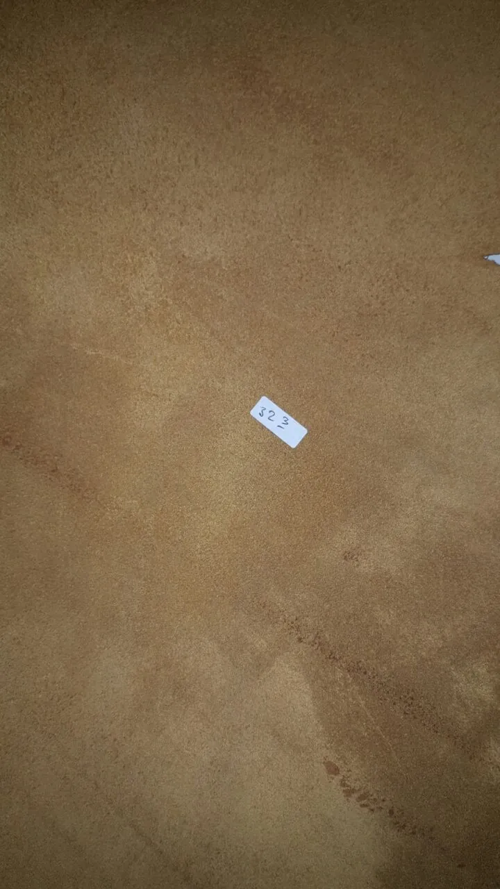 A close up view of the suede underside of a tan leather hide with a small white paper tag