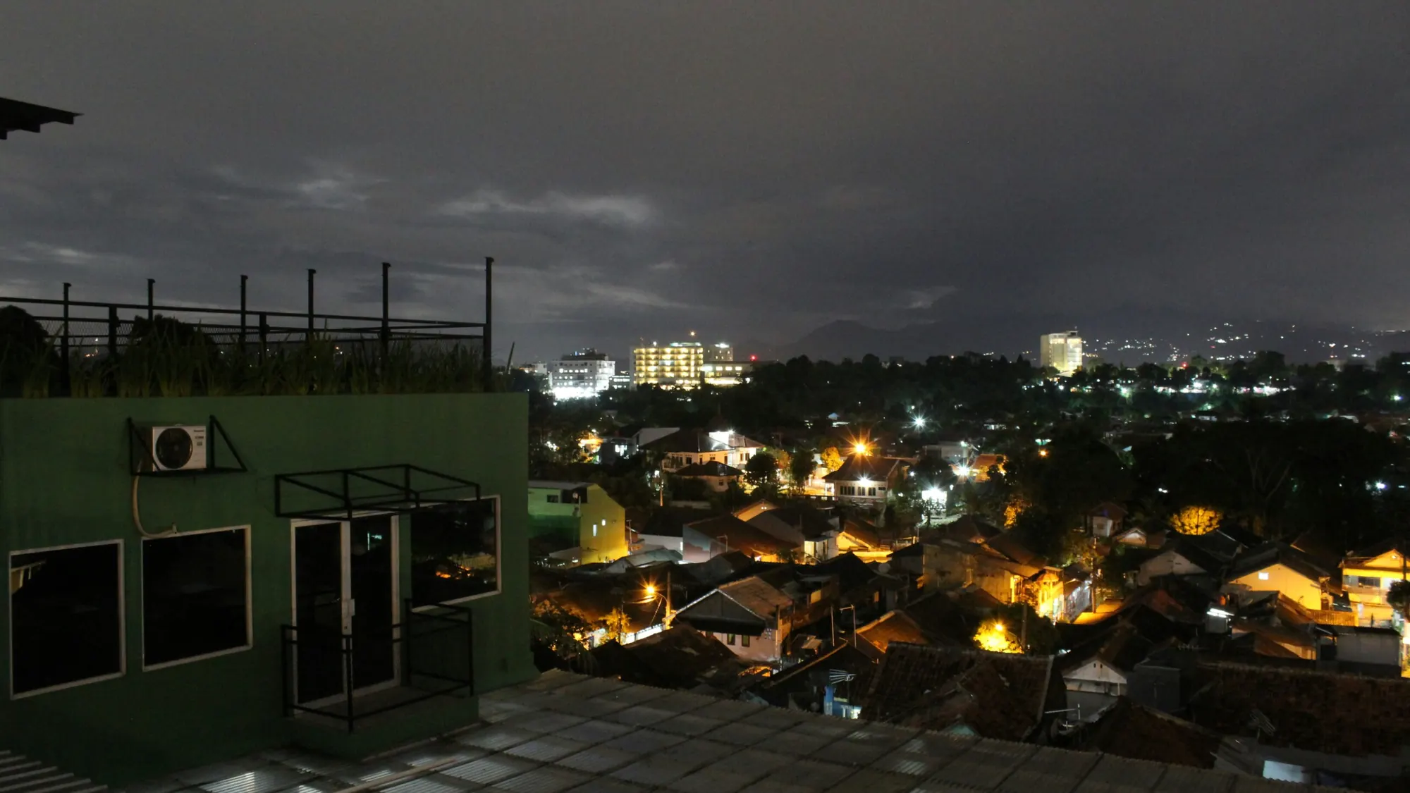 Pemandangan kota Bogor pada malam hari dari atap bengkel