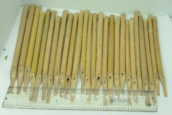 Deretan ujung pena bambu yang sudah diraut, disejajarkan dengan penggaris