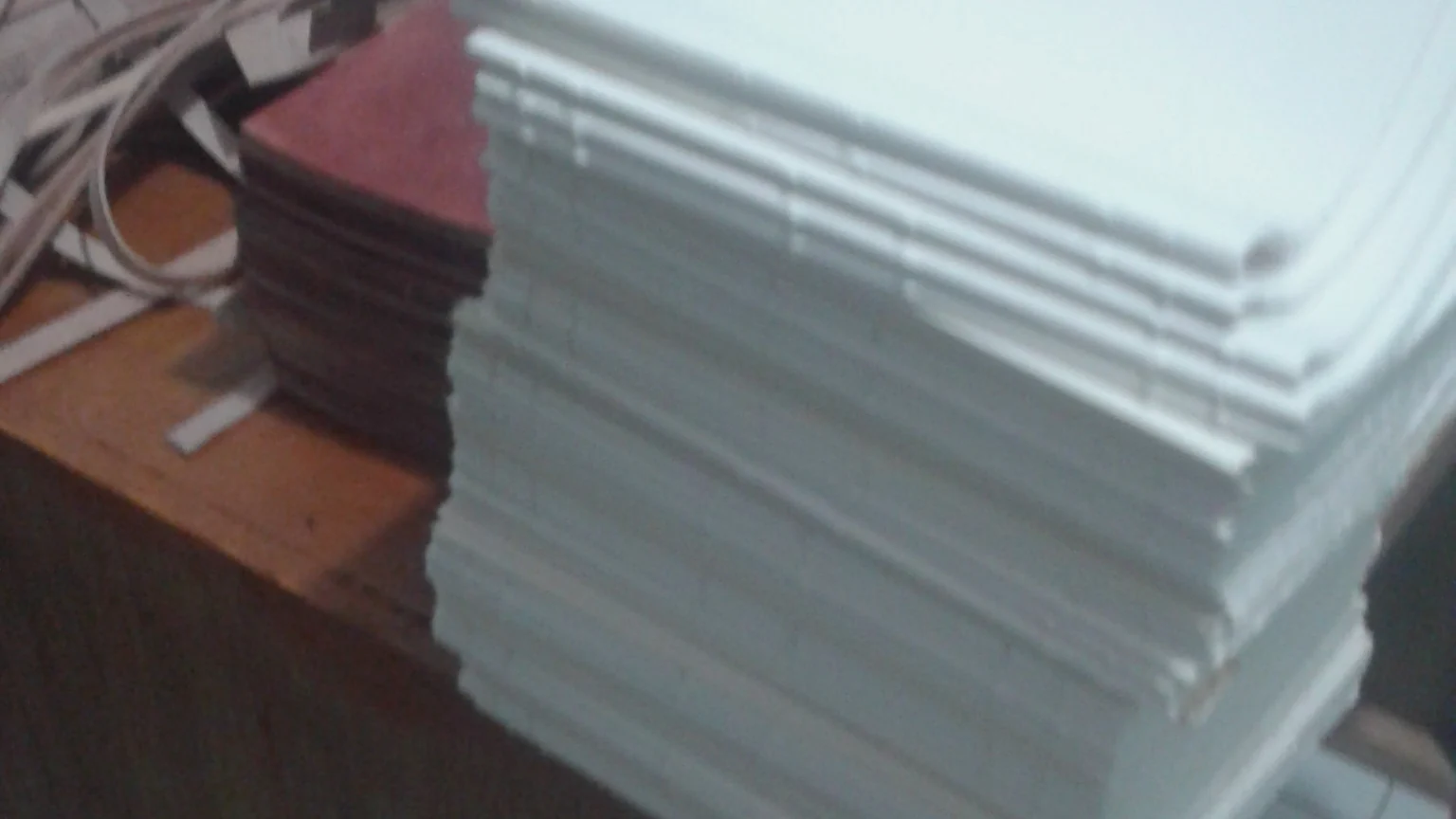 Tumpukan lipatan kertas putih di atas meja kayu bengkel