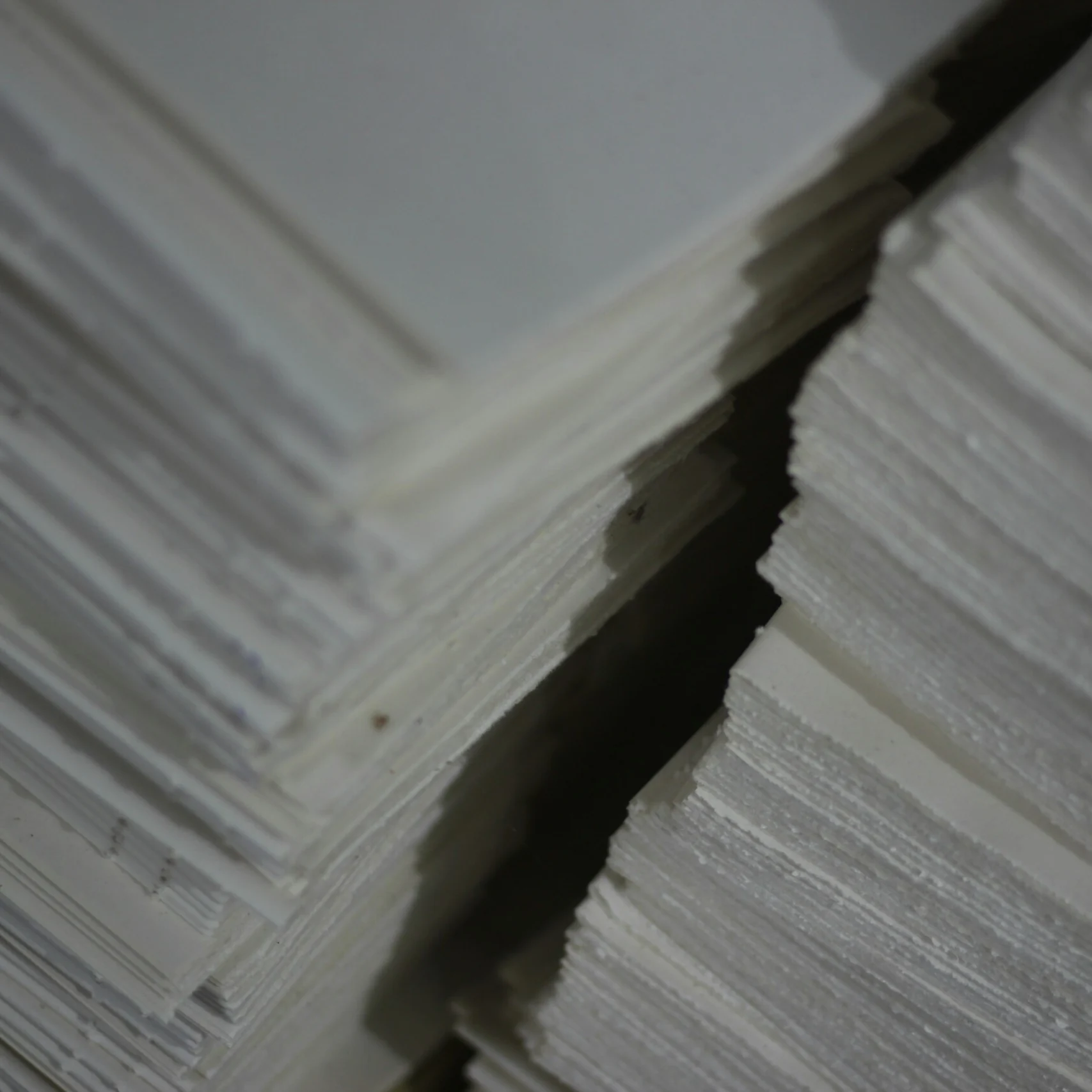 A stack of white paper sheets arranged neatly.
