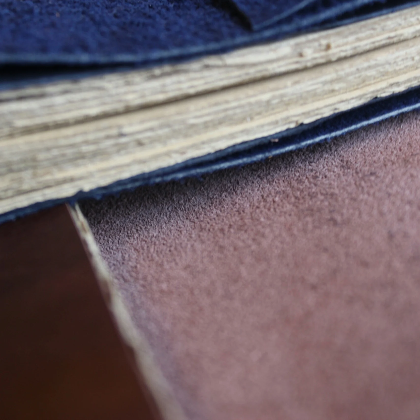 Tumpukan halaman buku dengan sampul kulit suede biru dan cokelat
