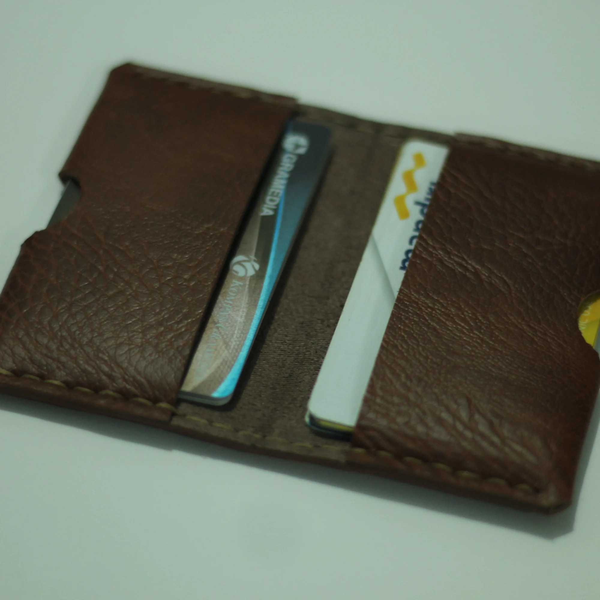 A brown leather card holder with cards inside.