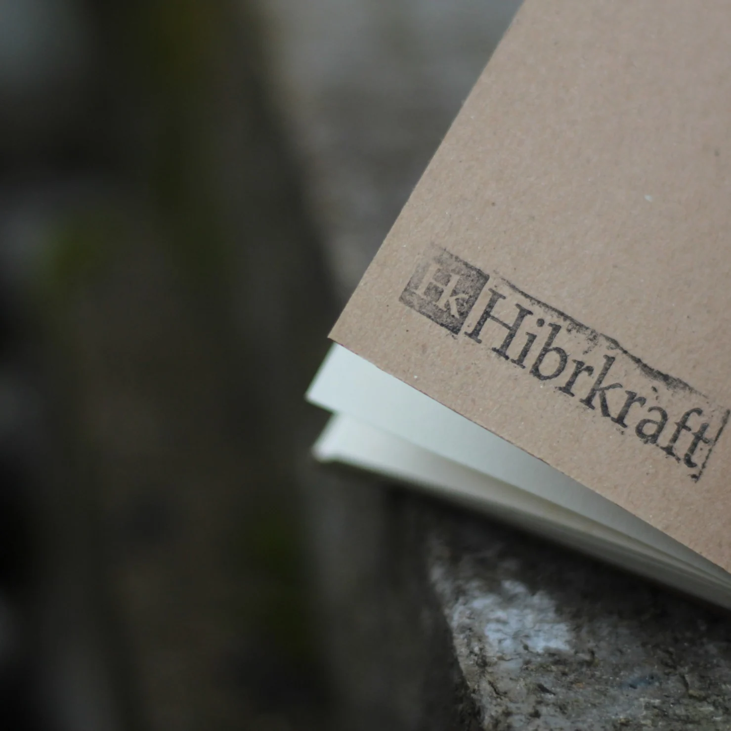Hibrkraft logo stamped on a brown notebook cover.