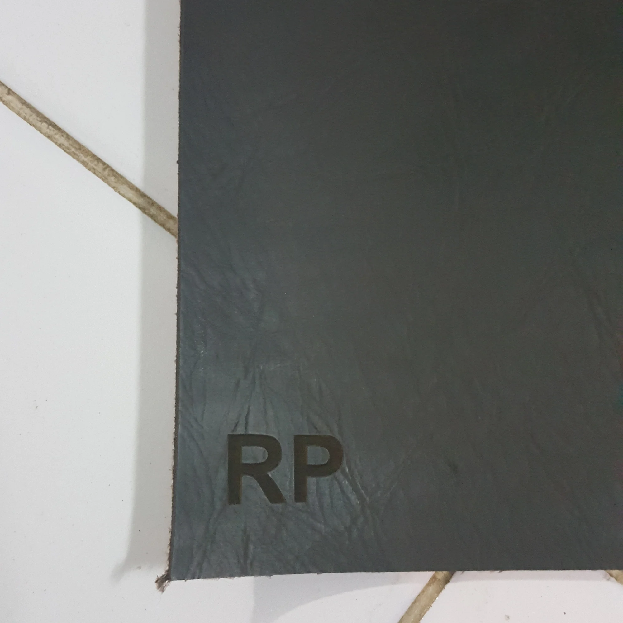 Lembar kulit gelap dengan inisial RP yang diemboss