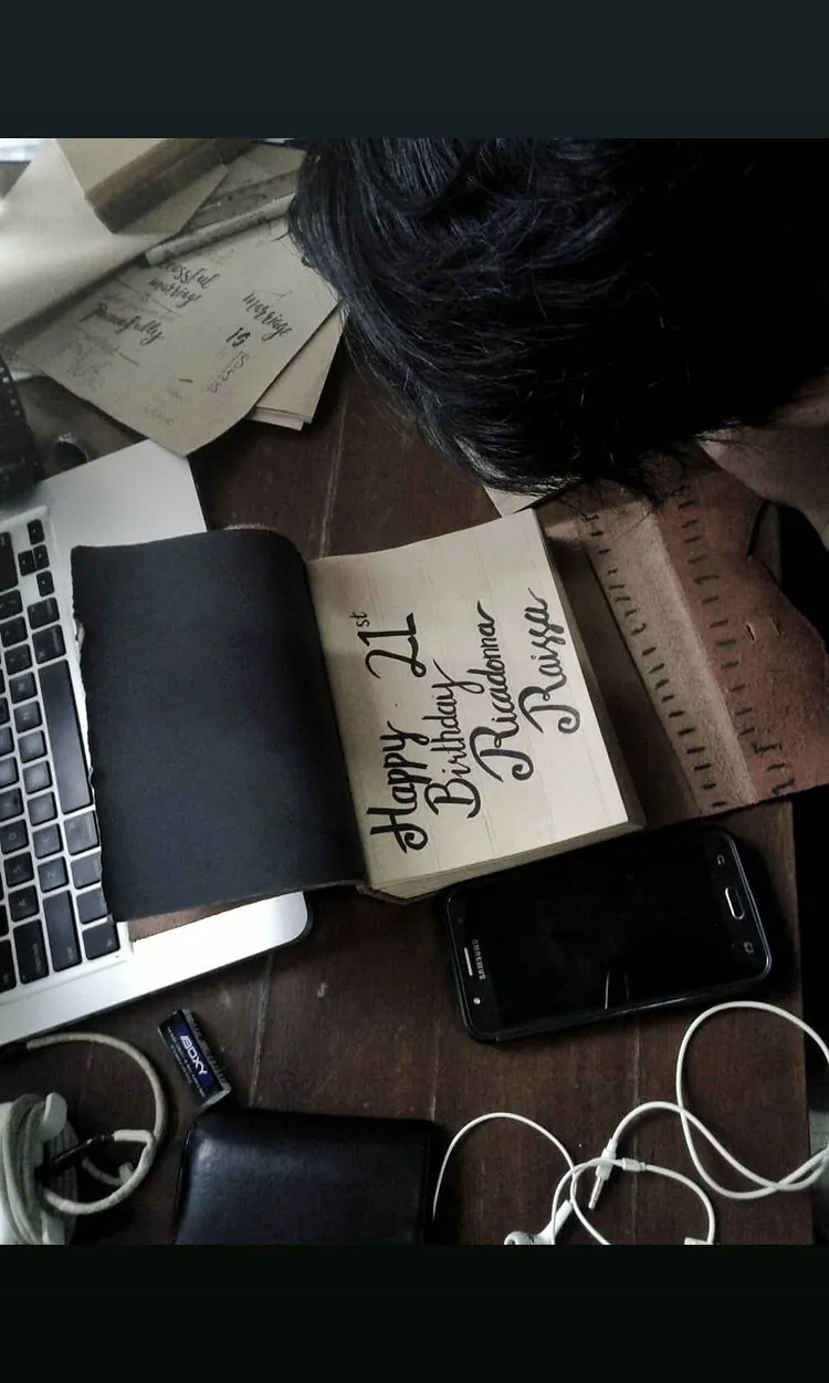 Story Instagram: ucapan ulang tahun ditulis tangan di jurnal terbuka, di meja bersama laptop, dompet dan ponsel