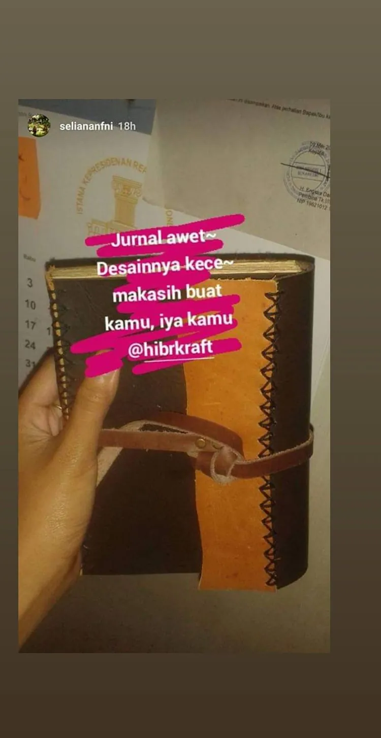 Story Instagram: tangan memegang jurnal kulit tan berjahit, dengan tulisan Jurnal awet, desainnya kece, makasih