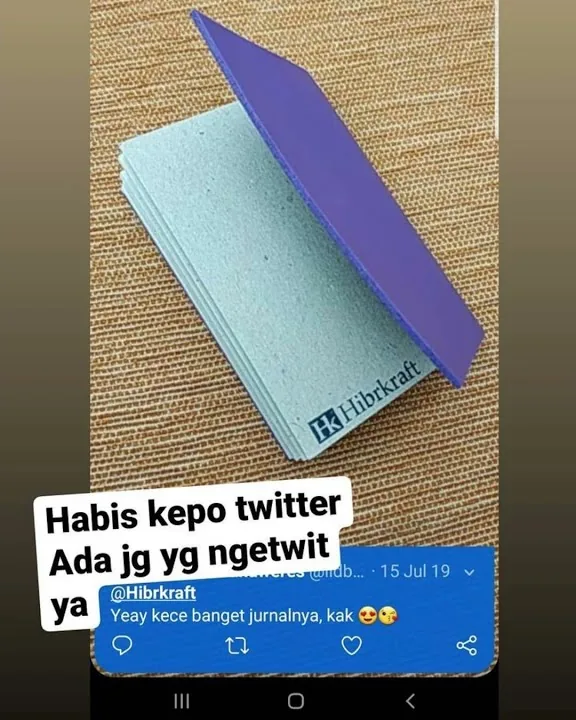 Jurnal Hibrkraft hijau mint di samping tangkapan layar sebuah twit