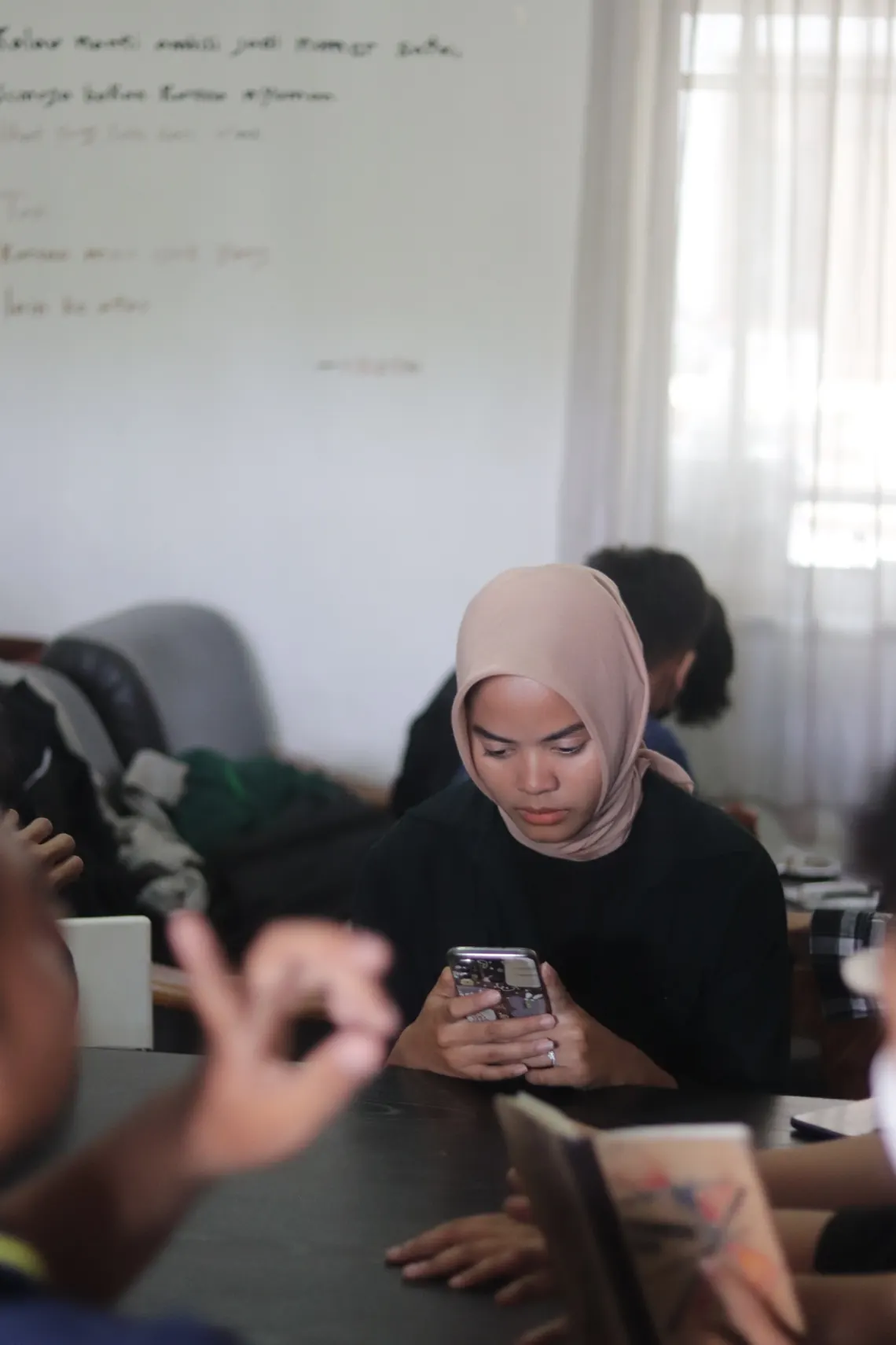 Perempuan berhijab menggunakan smartphone