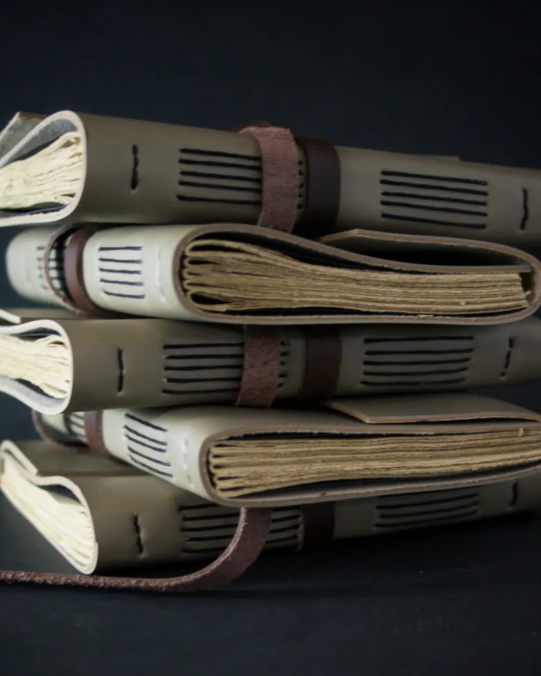 Stack of leather journals bound with coptic stitching, ready for branding