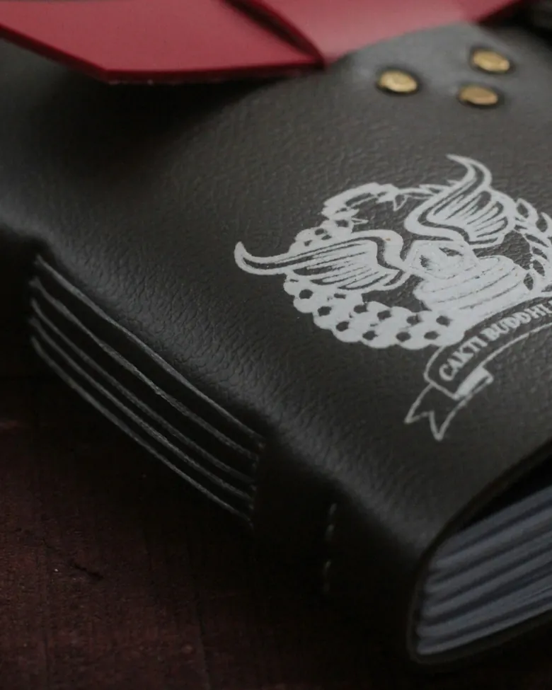 Jurnal kulit hitam dengan logo Cakti Buddhi Bhakti