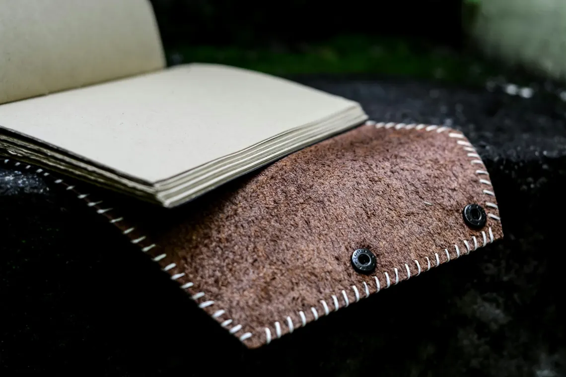 Jurnal kulit suede dengan kancing snap dilihat dari dekat