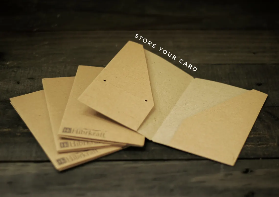 Beberapa dompet kartu kulit dengan warna dan finishing berbeda, tersusun berjajar di atas meja kayu.
