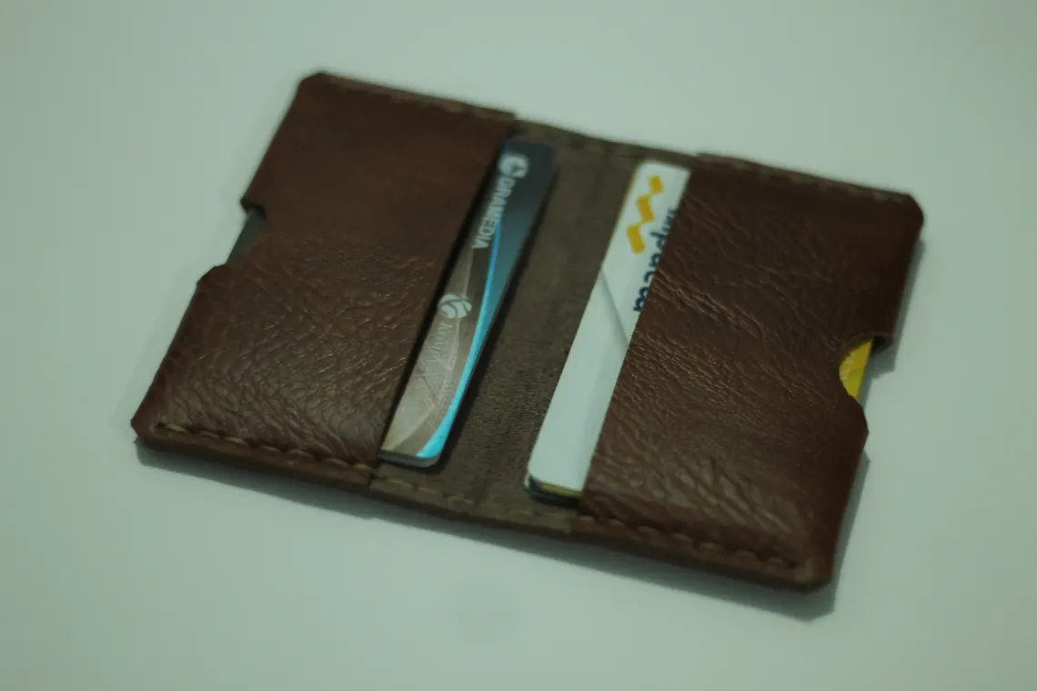 Dompet kartu kulit cokelat berisi beberapa kartu nama.