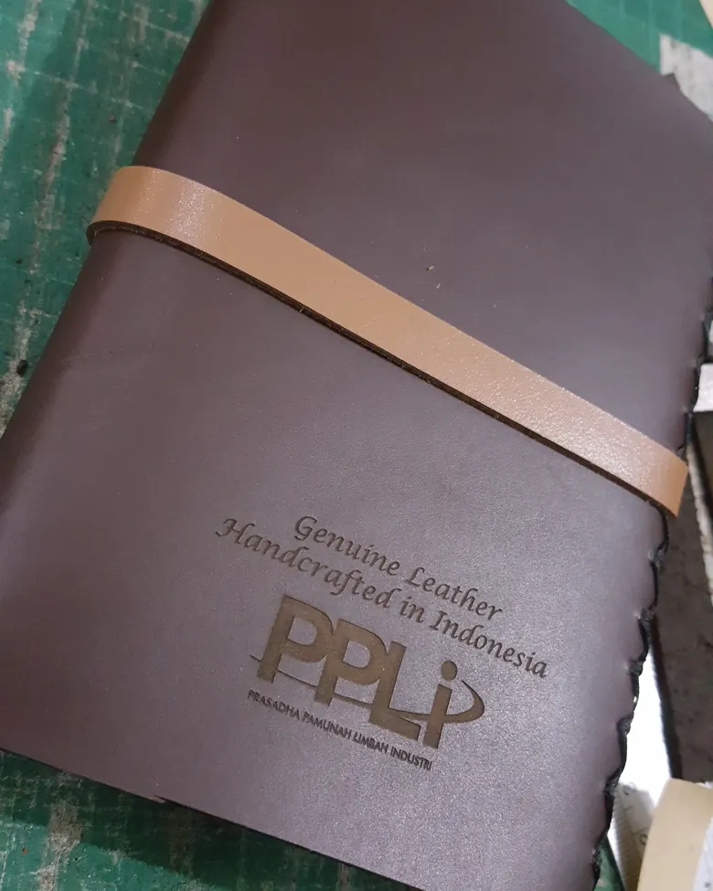 Jurnal kulit dengan logo klien yang di-deboss di sampul