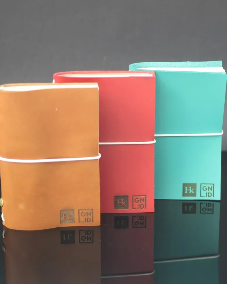 Deretan tiga jurnal kulit Hibrkraft dengan warna berbeda.