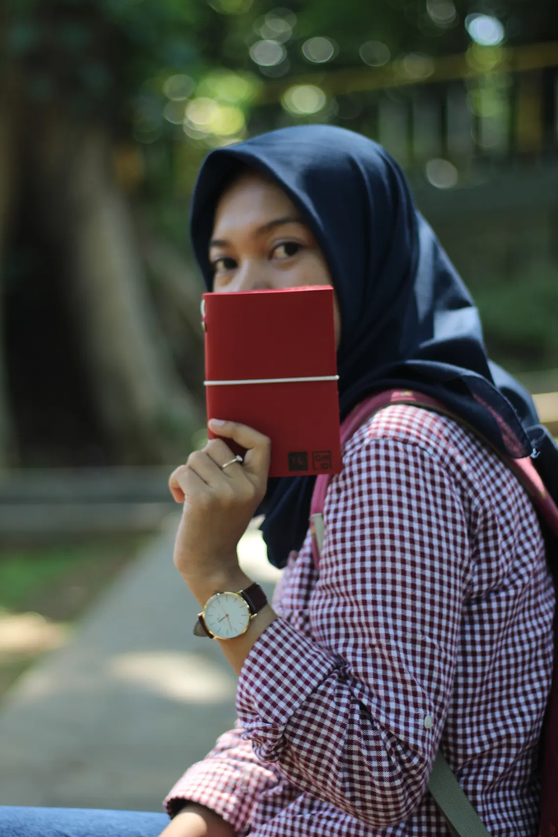 Seseorang memegang jurnal kulit merah bermodel Trevi.