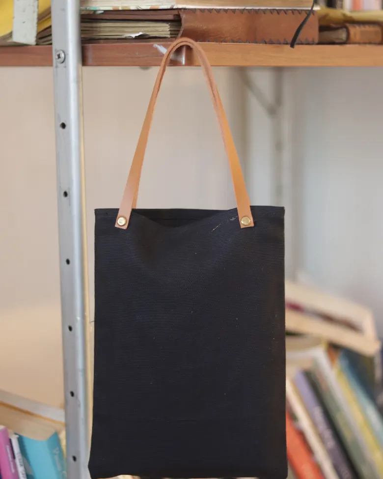 Tas tote kanvas hitam model Firhan dengan tali kulit.