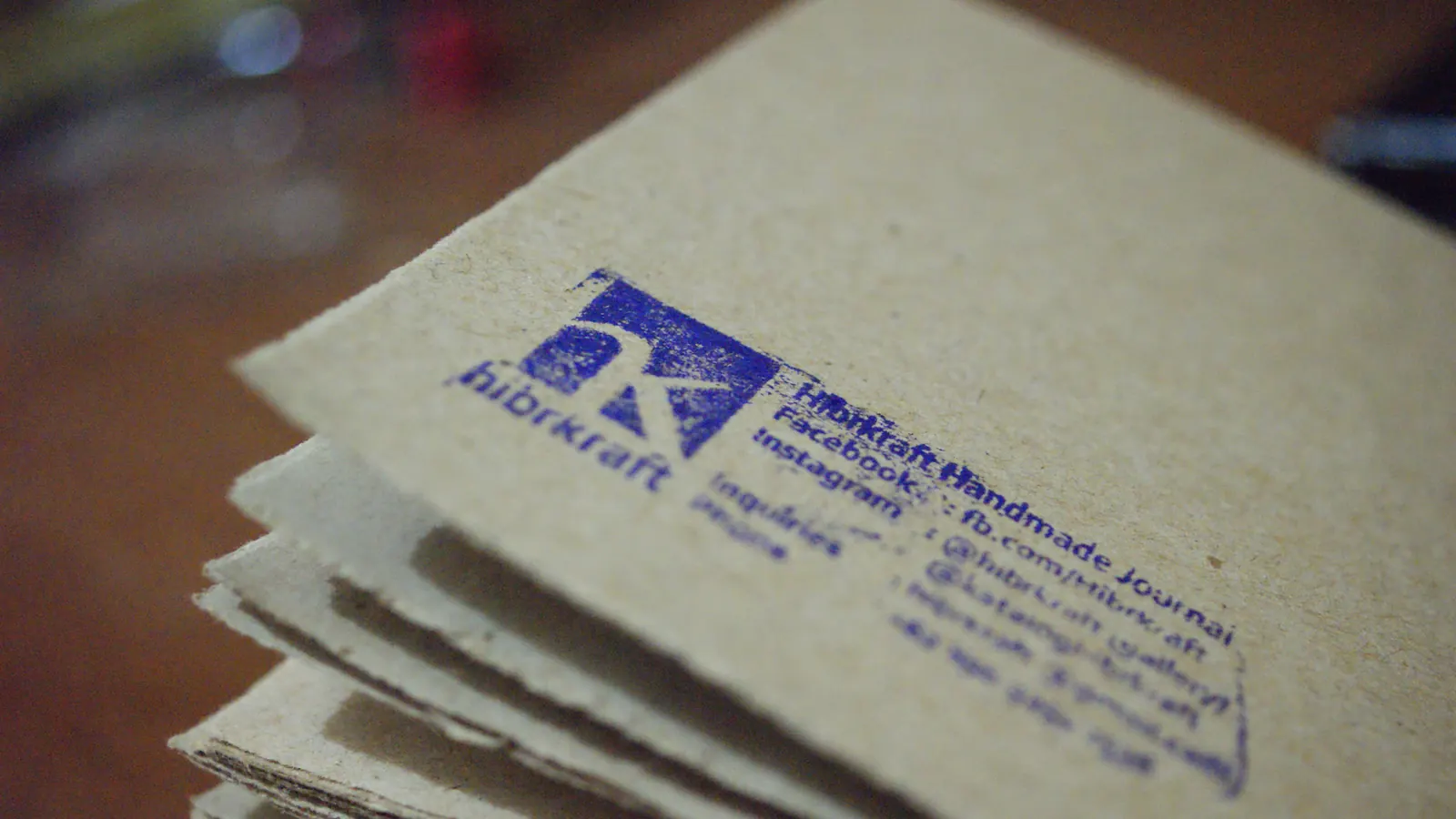 Logo Hibrkraft dicap di atas tumpukan kertas.